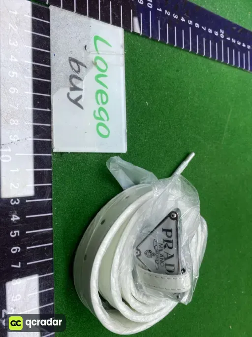 P-shaped silver buckle with white background and white belt