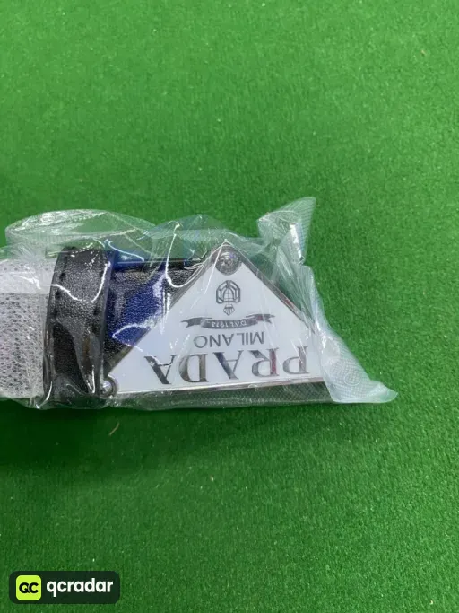 P-shaped silver buckle with black belt on white background